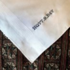 a white hankie on a patterned multi color background reads HQ77.9.B47